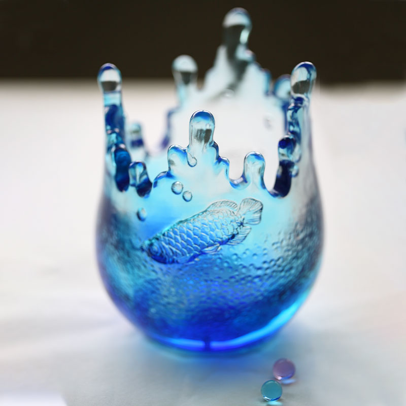 Blåa glasprydnader graverade med fiskmönster