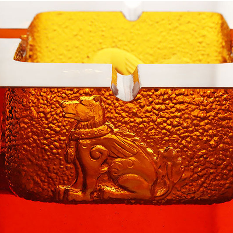 Röd askkopp i glas med utsökt präglade djurmönster