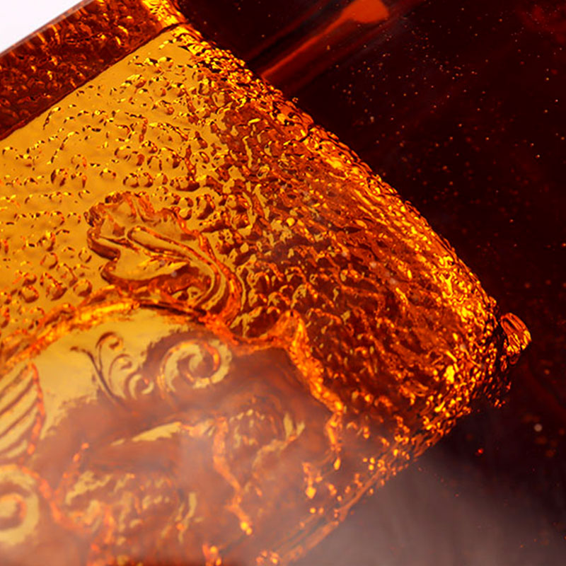 Röd askkopp i glas med utsökt präglade djurmönster