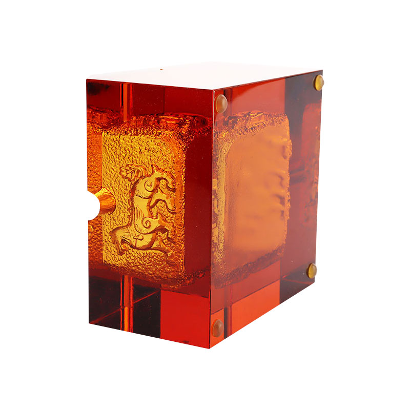 Röd askkopp i glas med utsökt präglade djurmönster