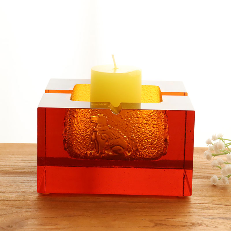 Röd askkopp i glas med utsökt präglade djurmönster