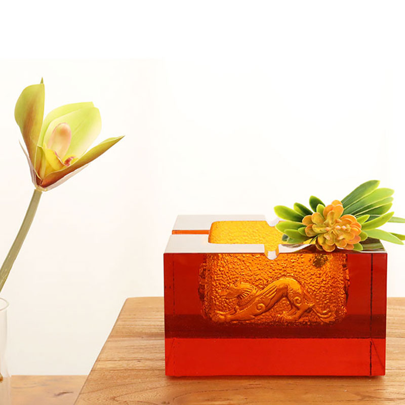 Röd askkopp i glas med utsökt präglade djurmönster