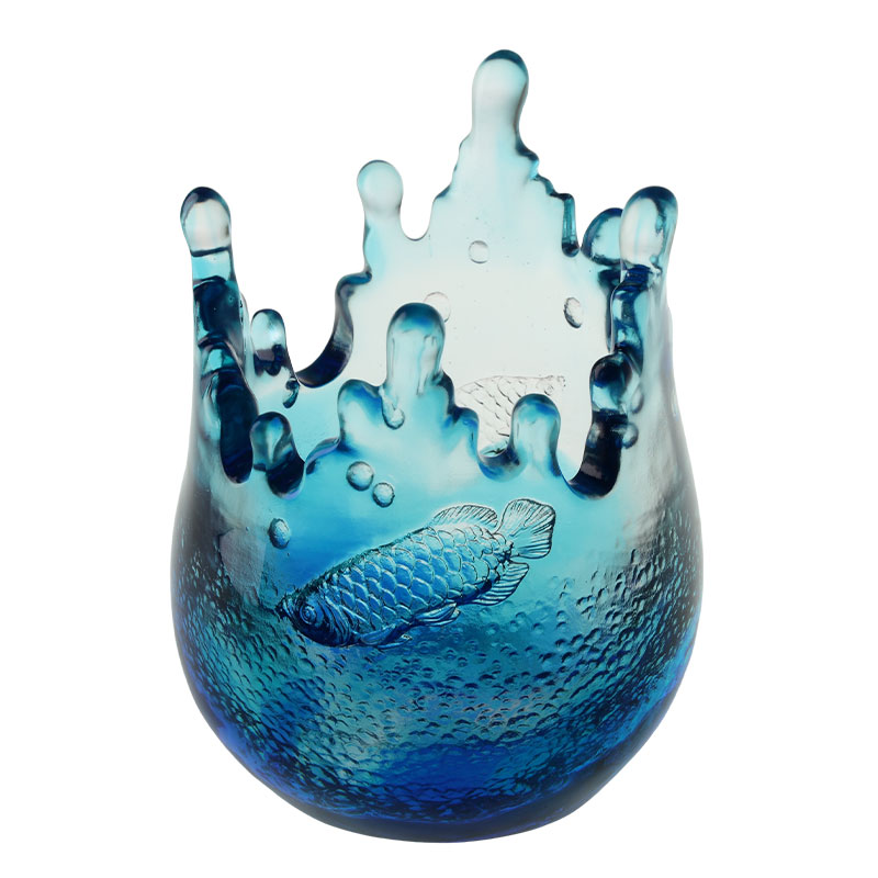 Blåa glasprydnader graverade med fiskmönster