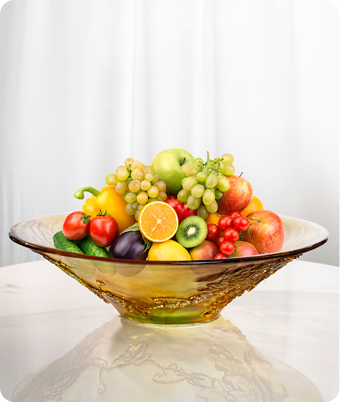 Ett glaskärl med bred mun laddat med frukter